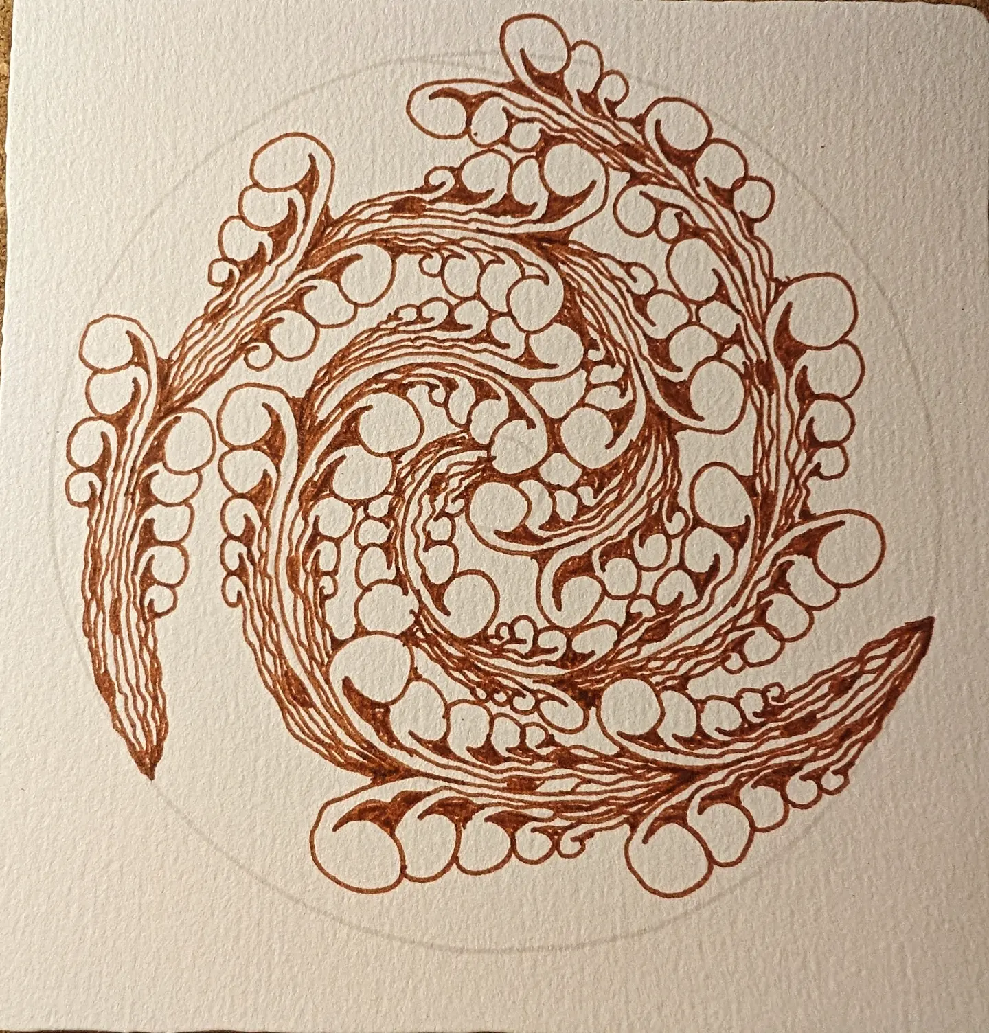 Hand-drawn flowing brown ink spiral pattern on cream paper