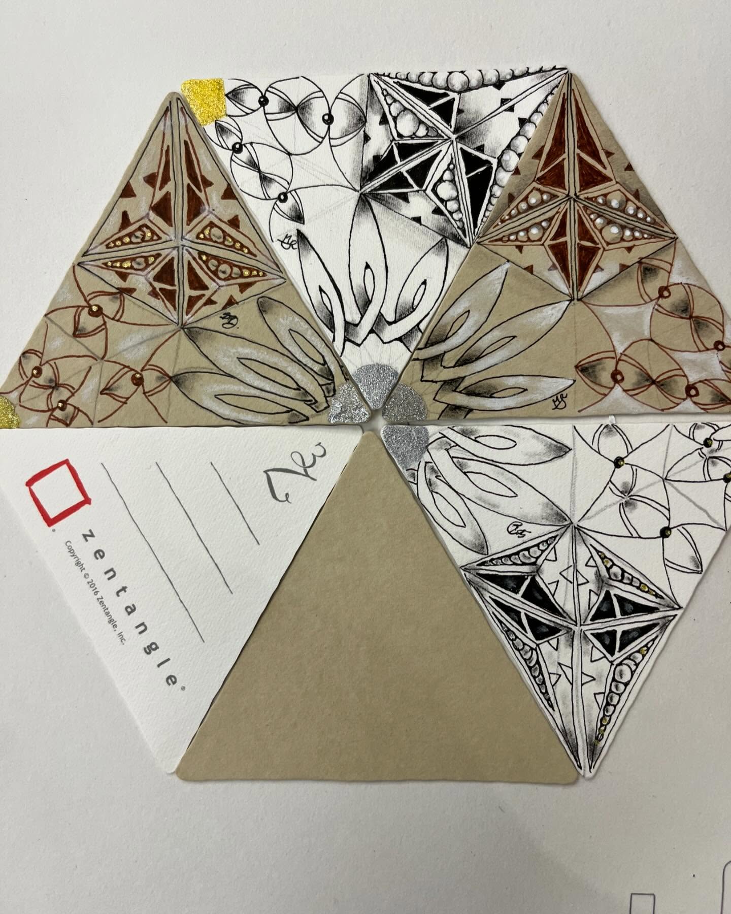 Arrangement of official Zentangle tiles hand-drawn with black and brown patterns and metallic accents